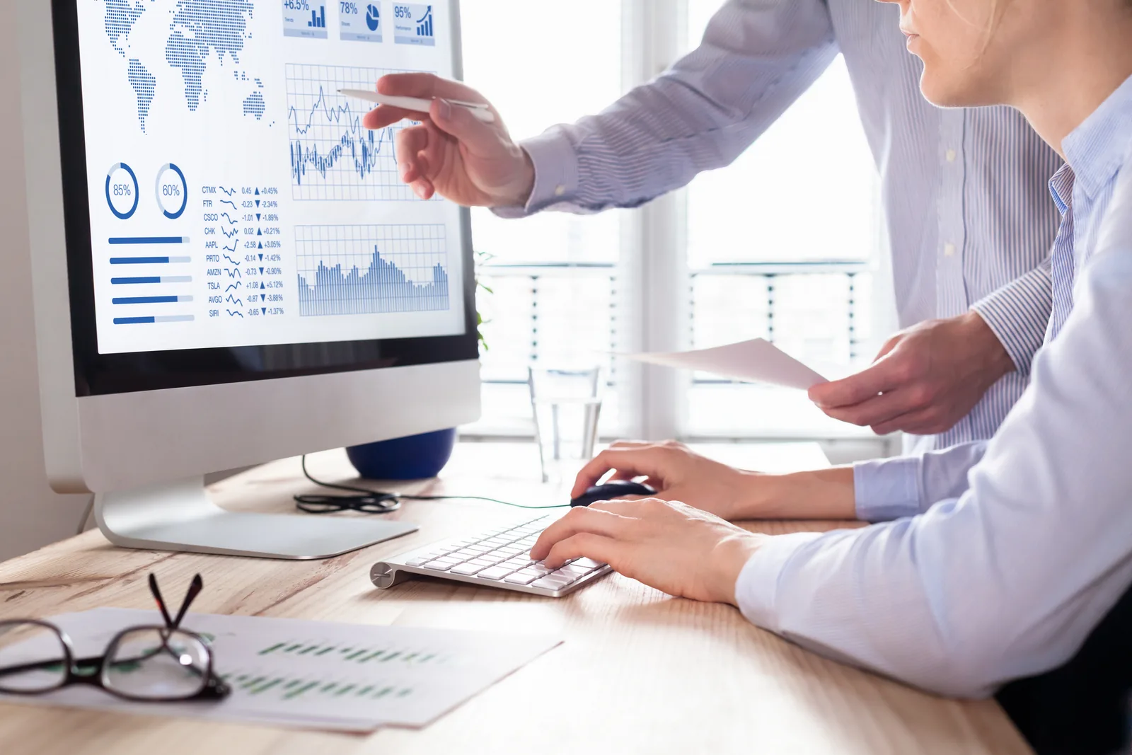 Analysts reviewing GIS data and dashboard outputs